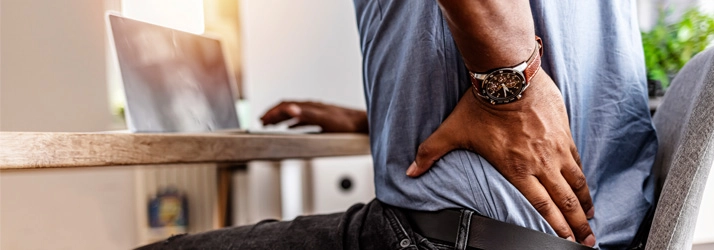 A man holding his lower back.