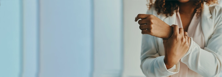 A woman holding her wrist in pain.