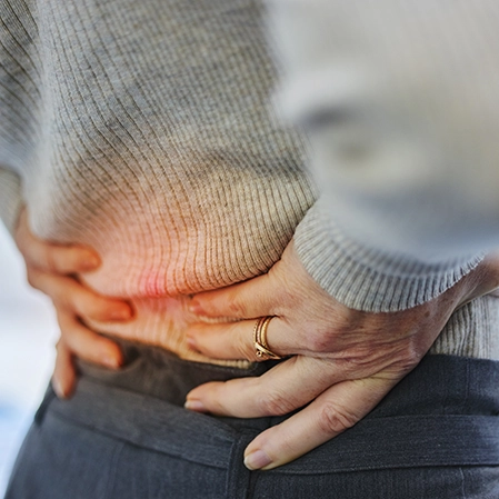 A woman holding her lower back.